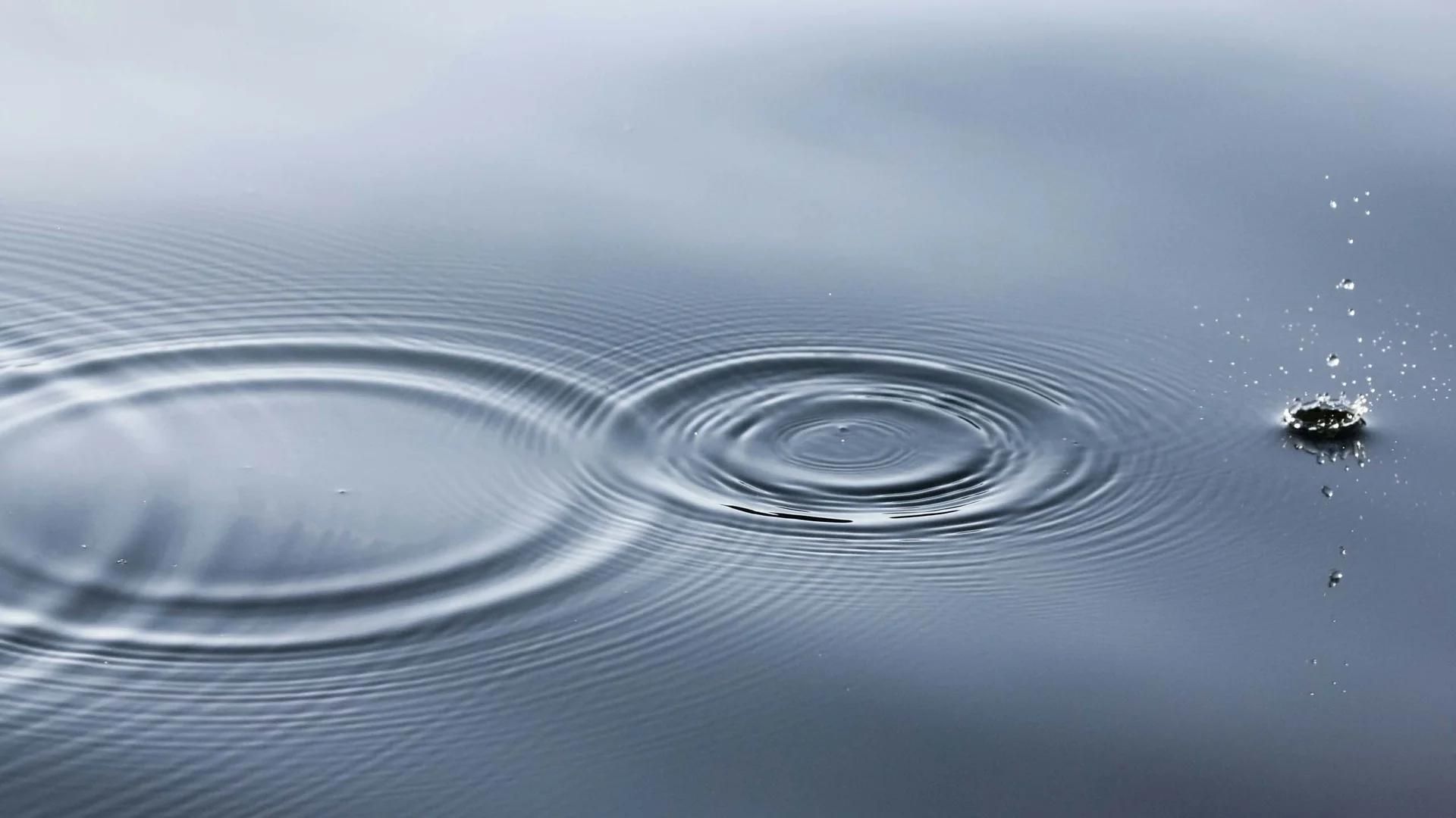 Ferienglück and Alpenland | Your stylish hotels in Ischgl Water surface with circular ripples and a small splash