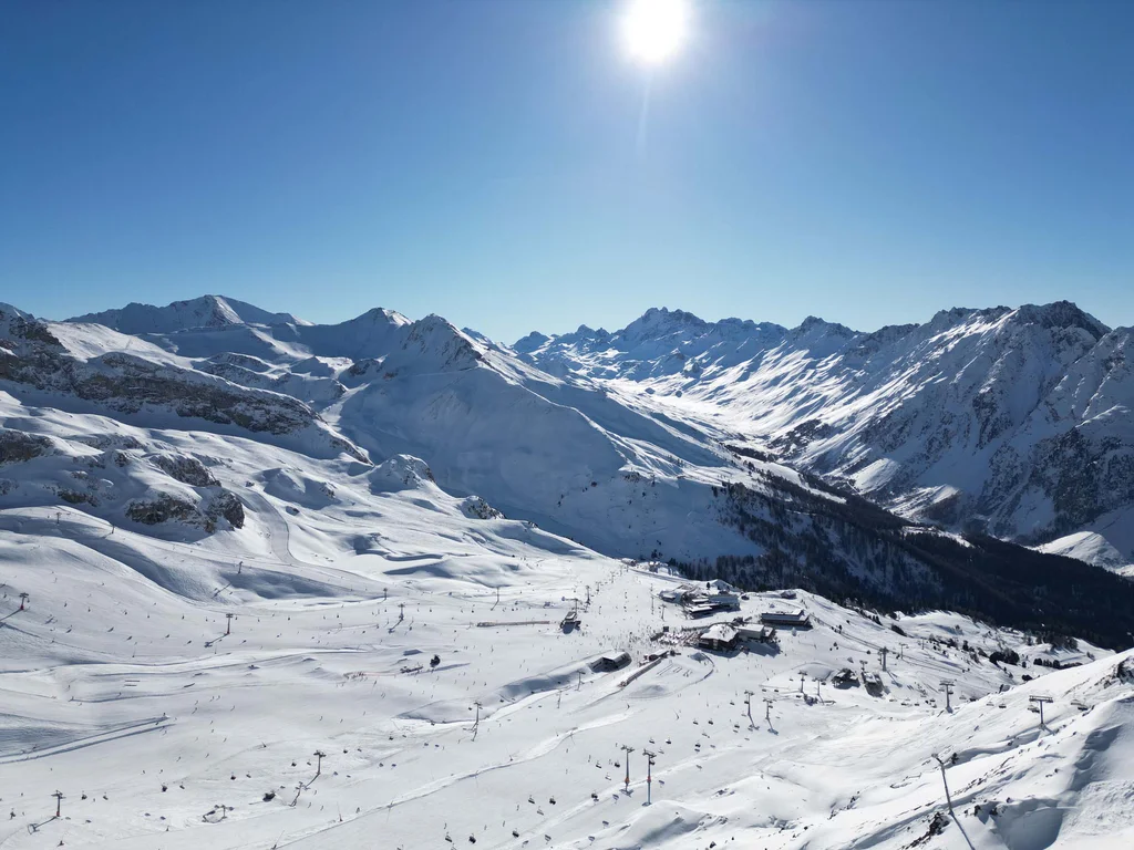 Ferienglück and Alpenland | Your stylish hotels in Ischgl Snow-covered mountain landscape with ski resort and chairlifts under a blue sky
