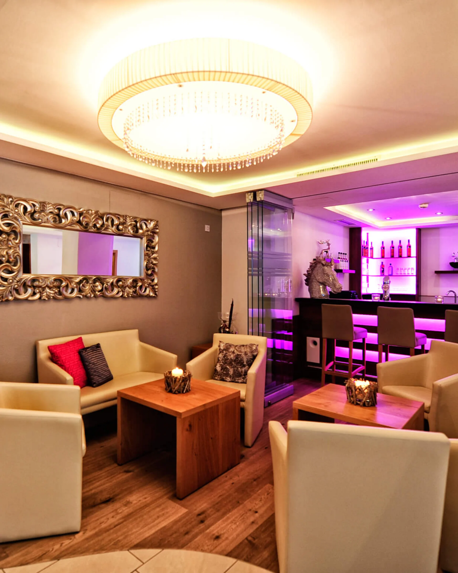 Ferienglück and Alpenland | Your stylish hotels in Ischgl Elegant hotel lounge with seating areas, chandelier and illuminated bar